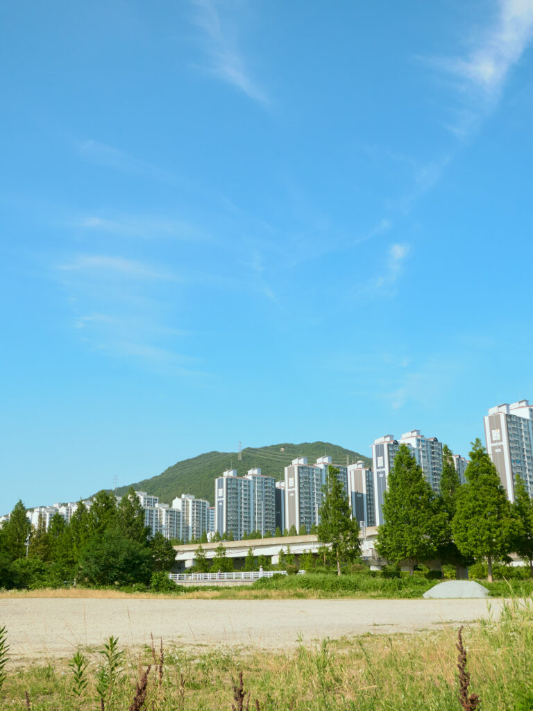 韓国の空き地とマンションと青い空の写真