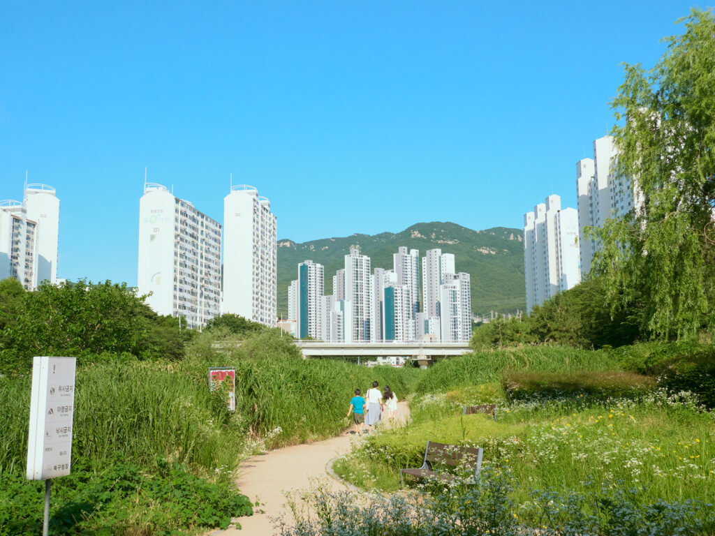 高層マンションに向かう三人の親子